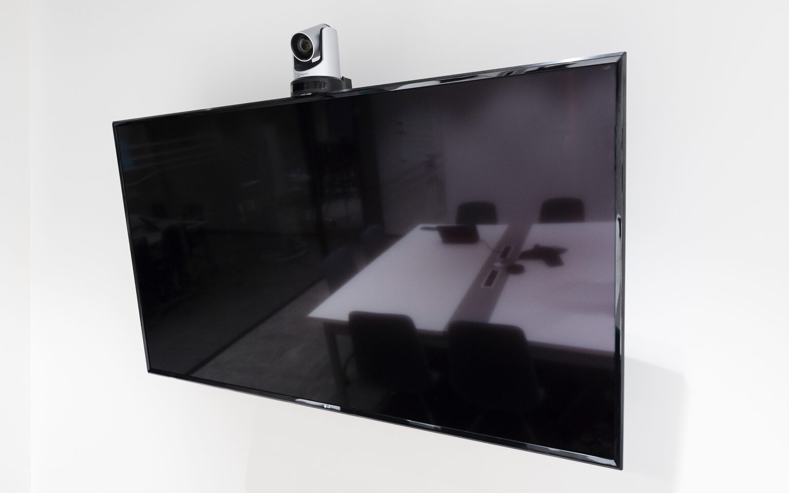 Monitor LG z kamerą PTZ Poly zamontowany na ścianie sali konferencyjnej IDEMIA