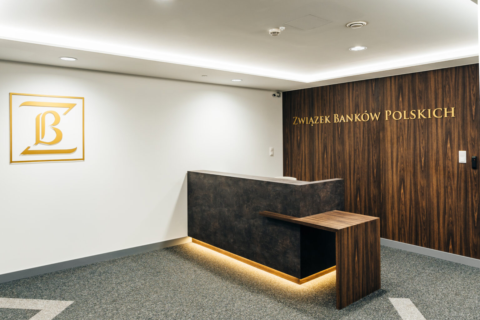 Recepcja w siedzibie Związku Banków Polskich z logo ZBP na drewnianej ścianie