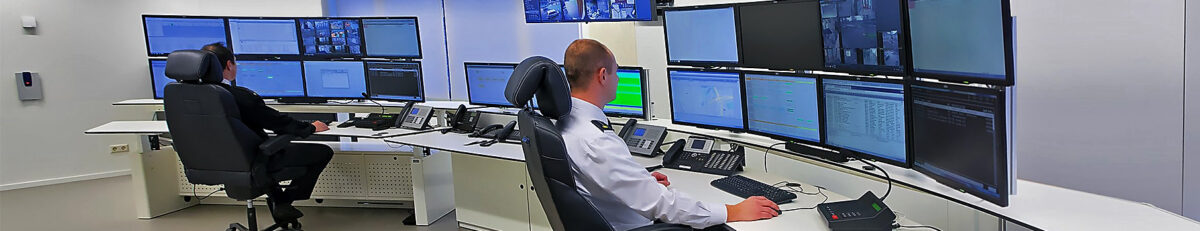 Operators at consoles with displays in an industrial plant dispatch centre