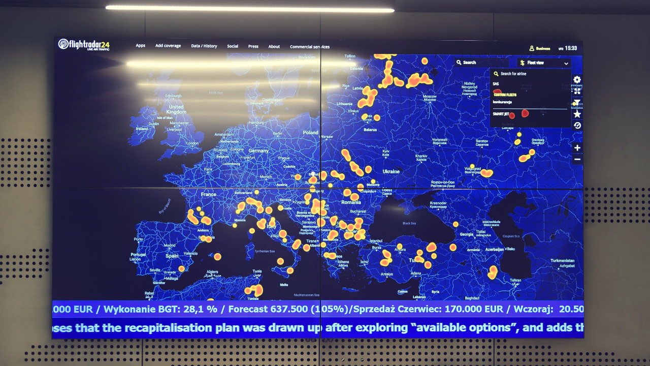 Ściana wideo w biurze Smart Jet z mapą Europy pokazującą położenie samolotów i paskiem informacyjnym u dołu ekranu – realizacja PROAV