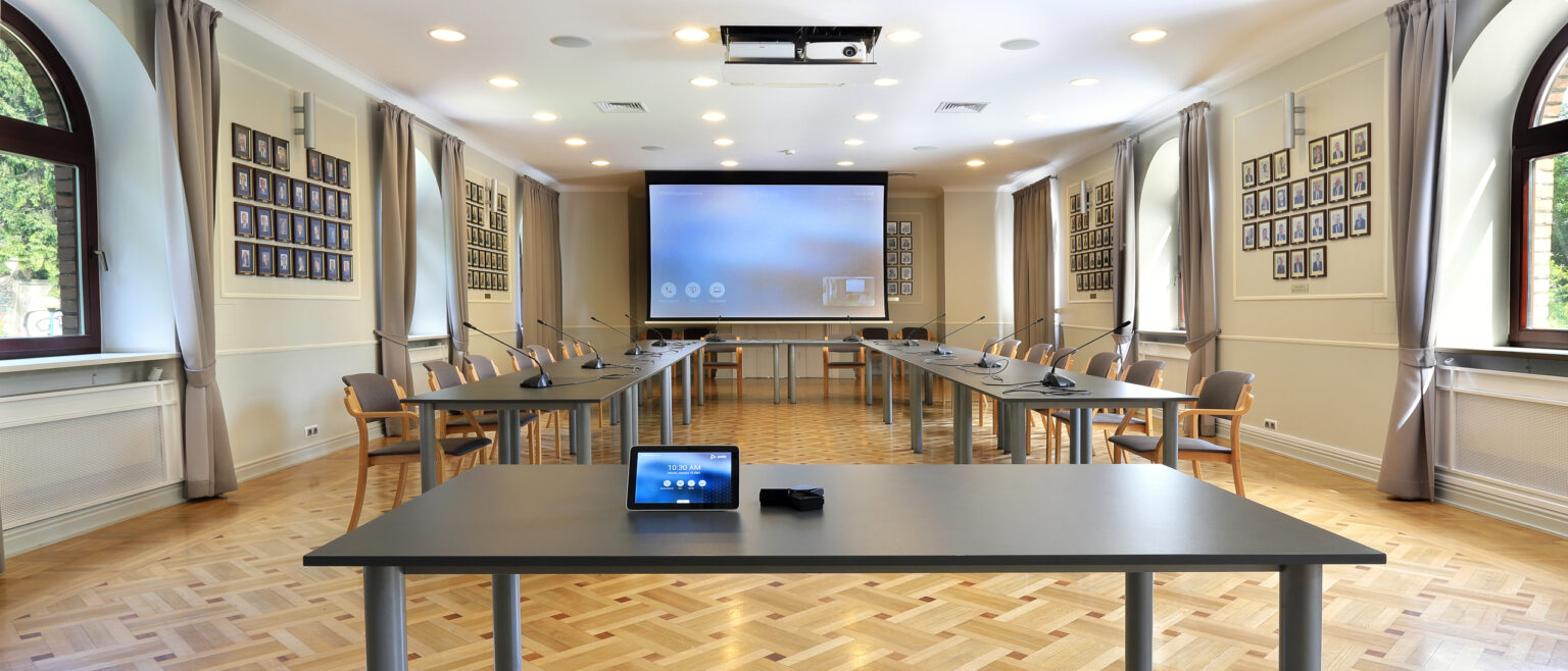 Panorama głównej sali spotkań Klubu Bankowca ZBP z ekranem projekcyjnym i stołami konferencyjnymi
