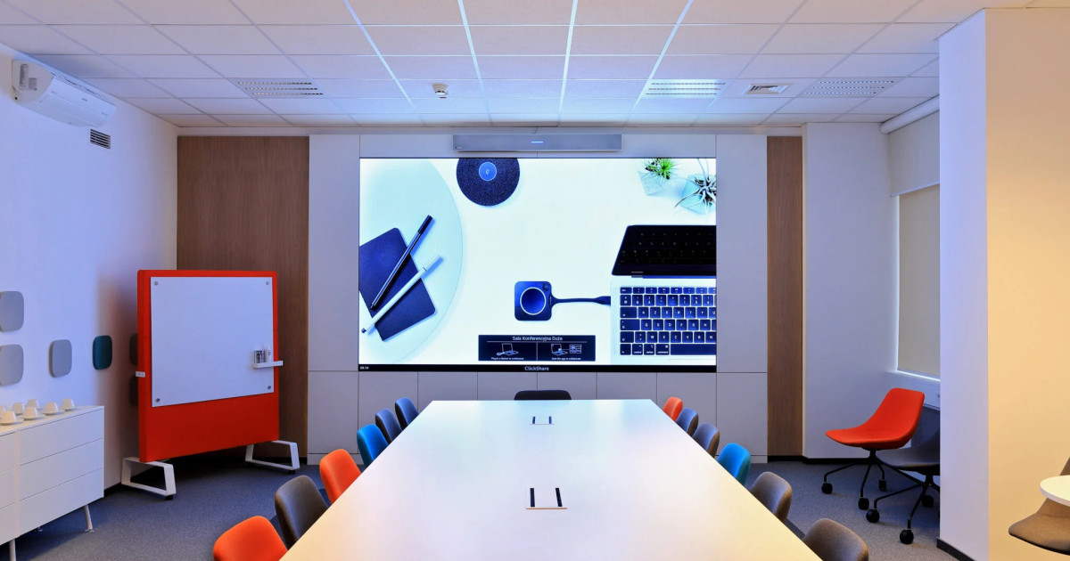 Duża sala konferencyjna Siemens z ekranem LED w zabudowie meblowej i kolorowymi krzesłami